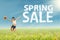 Woman jumps with spring sale sign