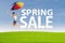 Woman jumps with spring sale sign