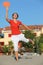Woman jumps with tennis racket on beach
