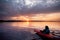 Woman in a kayak on the river on the scenic sunset