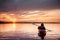 Woman in a kayak on the river on the scenic sunset