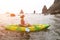 Woman kayak sea. Happy tourist takes sea photo in kayak canoe for memory. Woman traveler poses amidst volcanic mountains