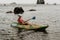 Woman kayak sea. Happy woman kayaks in sea, capturing outdoor memory with happy tourist taking photo. Volcanic mountains