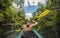 Woman Kayaking down a beautiful tropical jungle river