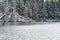 Woman kayaking on a snowy winter Lacamas Lake in the forest