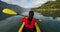Woman kayaking in Squamish paddling in kayak in Howe Sound a fjord surrounded by mountains. People living healthy active