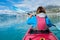 Woman kayaking on Styggvatnet glacier lake near Jostedalsbreen glacier.