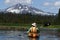 Woman kayaking toward snowy mountain peak