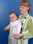 The woman keeps the baby in a baby sling