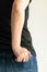 A woman keeps a short wallet in the back pocket of jeans on a white background with copy space