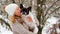 Woman kissing a french bulldog in the snow