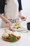 Woman in kitchen cooking stir vegetables on pan and tasting