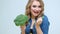 Woman in the kitchen eating fresh broccoli