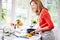 Woman In Kitchen Following Recipe On Digital Tablet