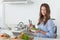 Woman in the kitchen holding a salad bowl with lettuce