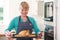 Woman In Kitchen Holding Tray With Roast Chicken