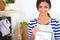 Woman in the kitchen at home, standing near desk with folder