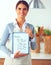 Woman in the kitchen at home, standing near desk with folder