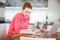 Woman in kitchen with laptop and a glass of wine