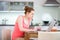 Woman in kitchen with laptop and a glass of wine