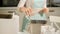 A woman in the kitchen prepares bread in a bread maker