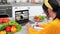 Woman in kitchen watch online webinar laptop listen chef, writes cooking recipe