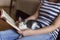 Woman and a kitten reading a book