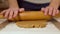 Woman kneading dough with a rolling pin for ginger cookies, closeup