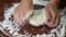 Woman kneading the dough on the wooden table