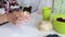 A woman kneads dough in her hands for making dumplings. Next on the table are blueberries and cherries for the filling