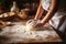 A woman kneads the dough on the kitchen table. Hands in flour close-up. Cooking bread in a rustic kitchen