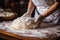 A woman kneads the dough on the kitchen table. Hands in flour close-up. Cooking bread in a rustic kitchen