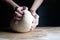 woman kneads dough on a table