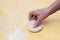 A woman kneads her hands with a small cake of raw dough