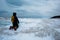 Woman kneeling on frozen wave looking into the distance