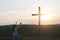 A woman is kneeling with her hands up. Near the cross. Prayer of repentance. Christian faith.