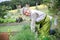 Woman kneeling to work in garden