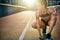 Woman kneels with one hand on pavement and smiles