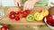 Woman knife regimen of strawberries for fruit salad
