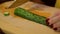 Woman knife slices fresh cucumber on a wooden board