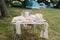 Woman knits bag using macrame technique outdoors near tents. Outdoor hobbies.