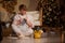 Woman knits baskets with a thread key in a cozy house on Christmas evening.