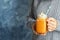 Woman in knitted sweater holding mason jar with pumpkin spice latte on color background.