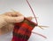 A woman knitting red woolen socks. Knitting close up on a white background. Hand crafts.