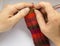 A woman knitting red woolen socks. Knitting close up on a white background. Hand crafts.