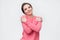 Woman l keeping arms around herself, enjoying soft fabric of her pink sweater