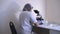 Woman lab technician enters to sit down at his workplace laboratory for work virus test