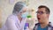 Woman lab technician taking a saliva test from a man`s mouth with a cotton swab slow mo