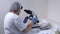 Woman laboratory assistant moves the slide and analyzes the biological material