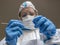 A woman, laboratory technician, completely covered in a white protective suit, makes a test swab to check for Covid-19 Coronavirus